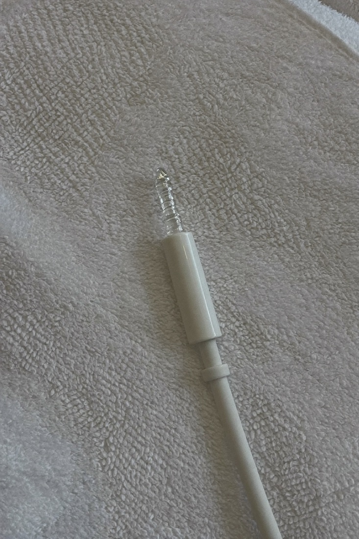 The tip of the laser handpiece resting on a towel