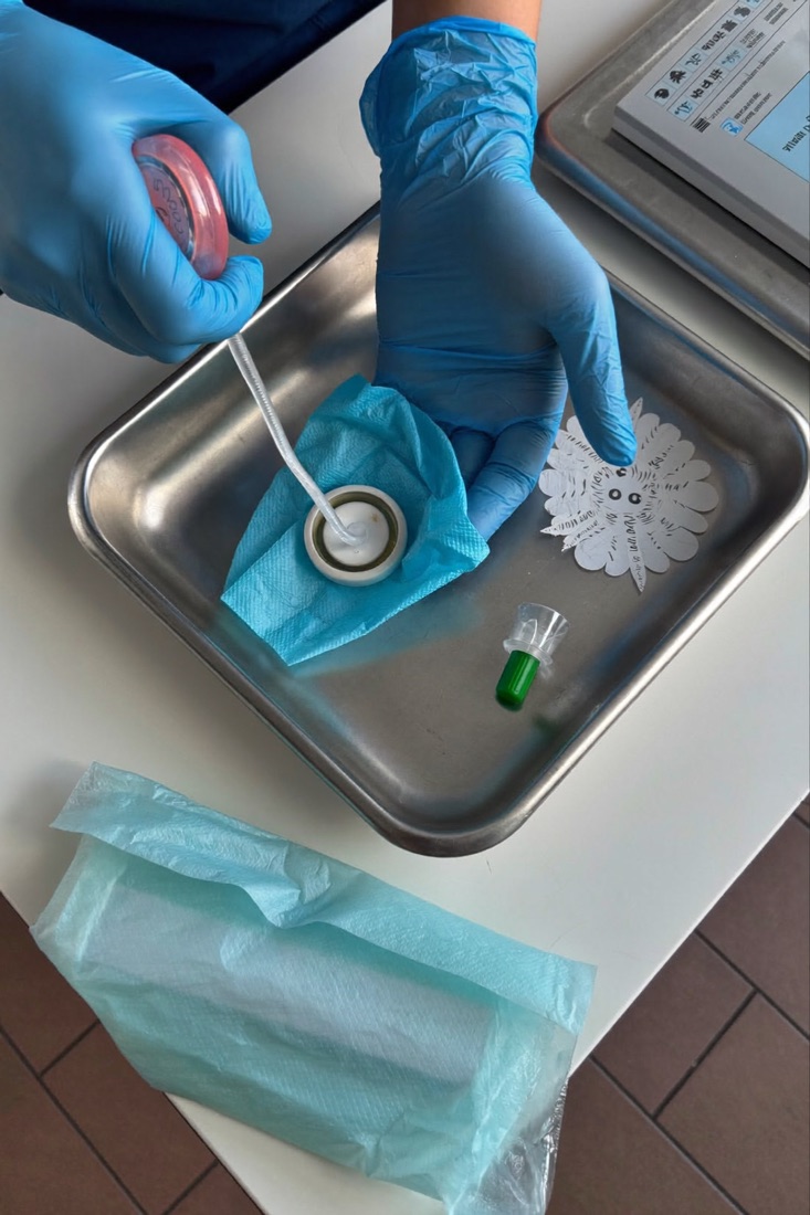 Gloved hands preparing a sterile tray; no patient shown
